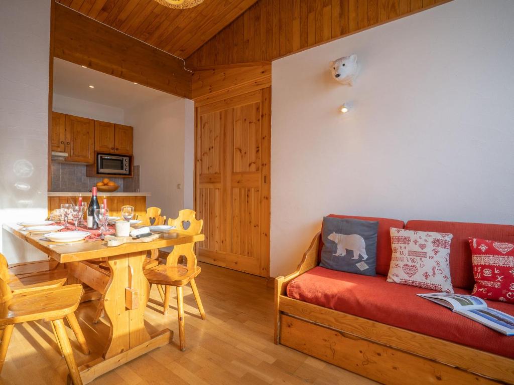 un salon avec un canapé rouge et une table dans l'établissement Apartment Le Curling B - Val Claret-21 by Interhome, à Tignes