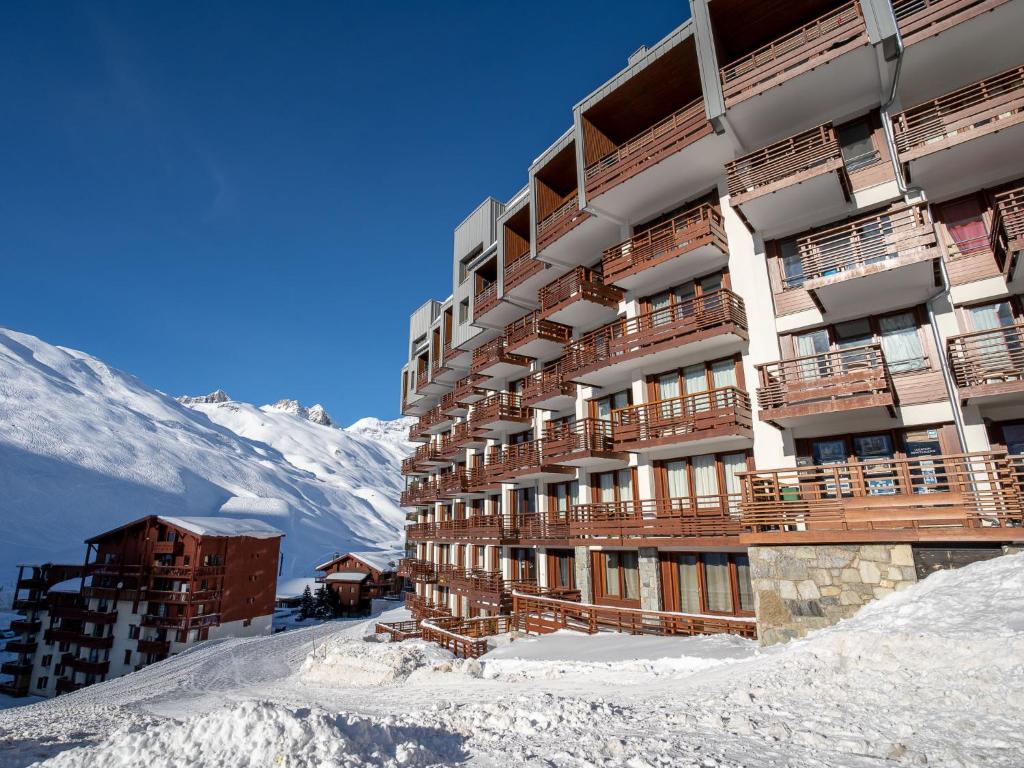 un bâtiment dans la neige avec une montagne en arrière-plan dans l'établissement Apartment Le Curling B - Val Claret-9 by Interhome, à Tignes
