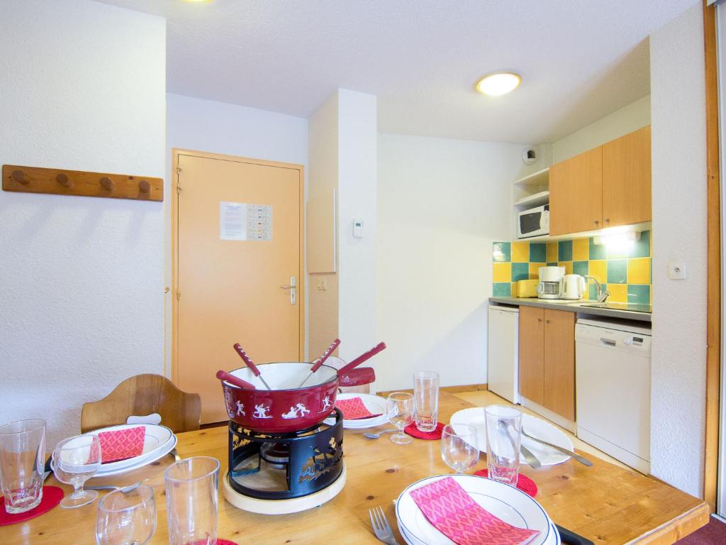 une cuisine avec une table avec des assiettes et des verres dessus dans l'établissement Apartment Bâtiment A-13 by Interhome, au Corbier