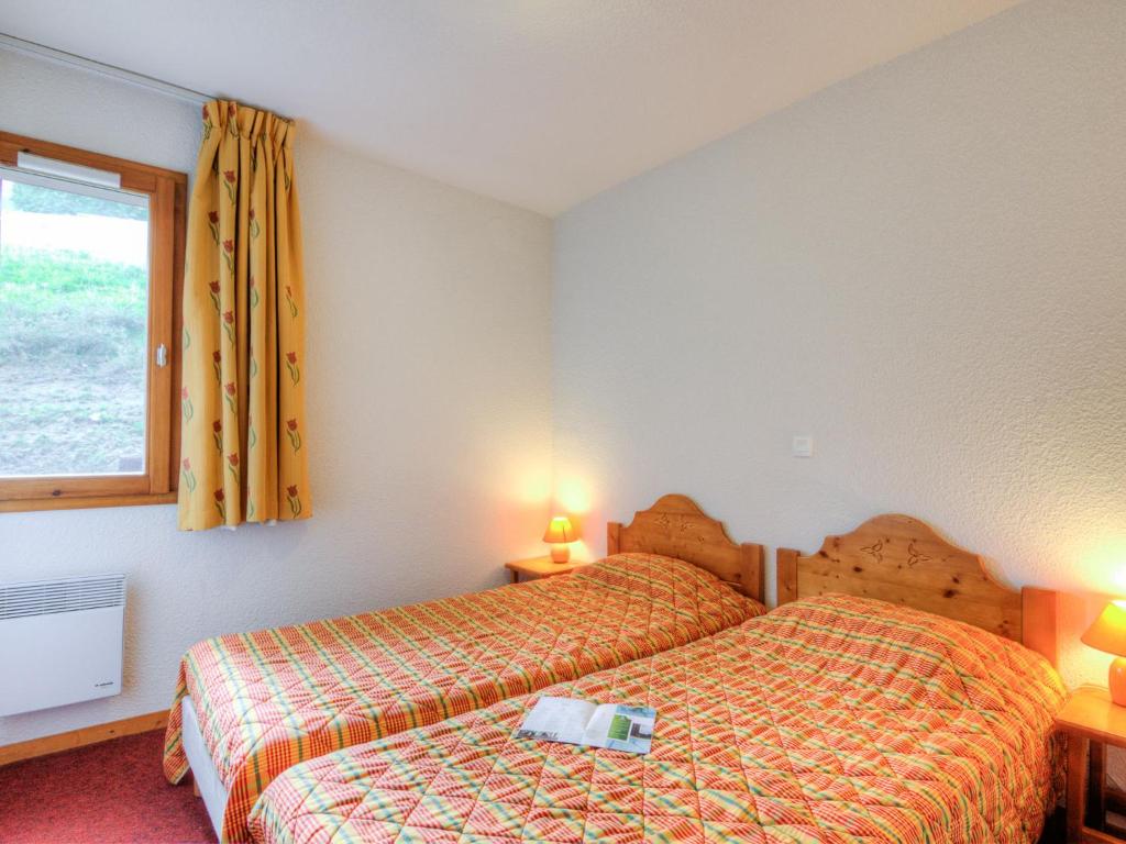 une chambre d'hôtel avec deux lits et une fenêtre dans l'établissement Apartment Bâtiment A-13 by Interhome, au Corbier