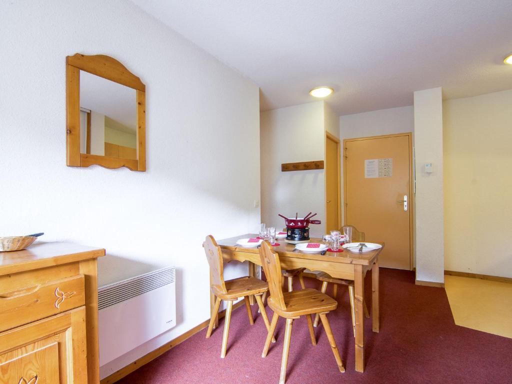 Cette chambre comprend une table, des chaises et un miroir. dans l'établissement Apartment Bâtiment A-13 by Interhome, au Corbier 20 autres photos
