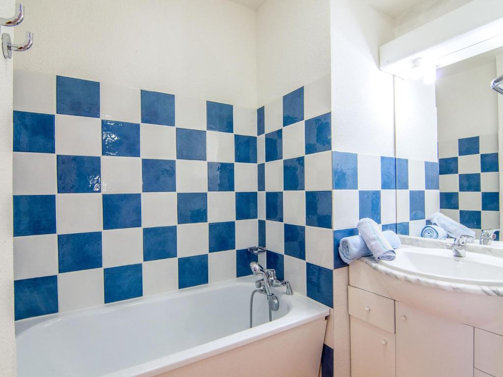La salle de bains est pourvue de carrelage bleu et blanc. dans l'établissement Apartment Bâtiment A-13 by Interhome, au Corbier