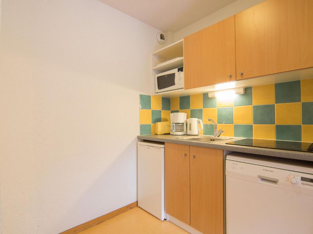 une petite cuisine avec un évier et un micro-ondes dans l'établissement Apartment Bâtiment A-13 by Interhome, au Corbier