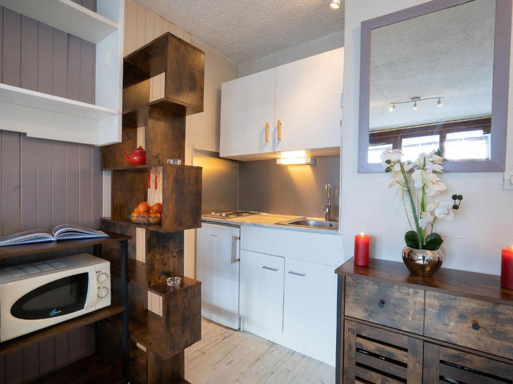 une cuisine avec des placards blancs et un four micro-ondes sur un comptoir dans l'établissement Apartment Le Curling B - Val Claret-30 by Interhome, à Tignes