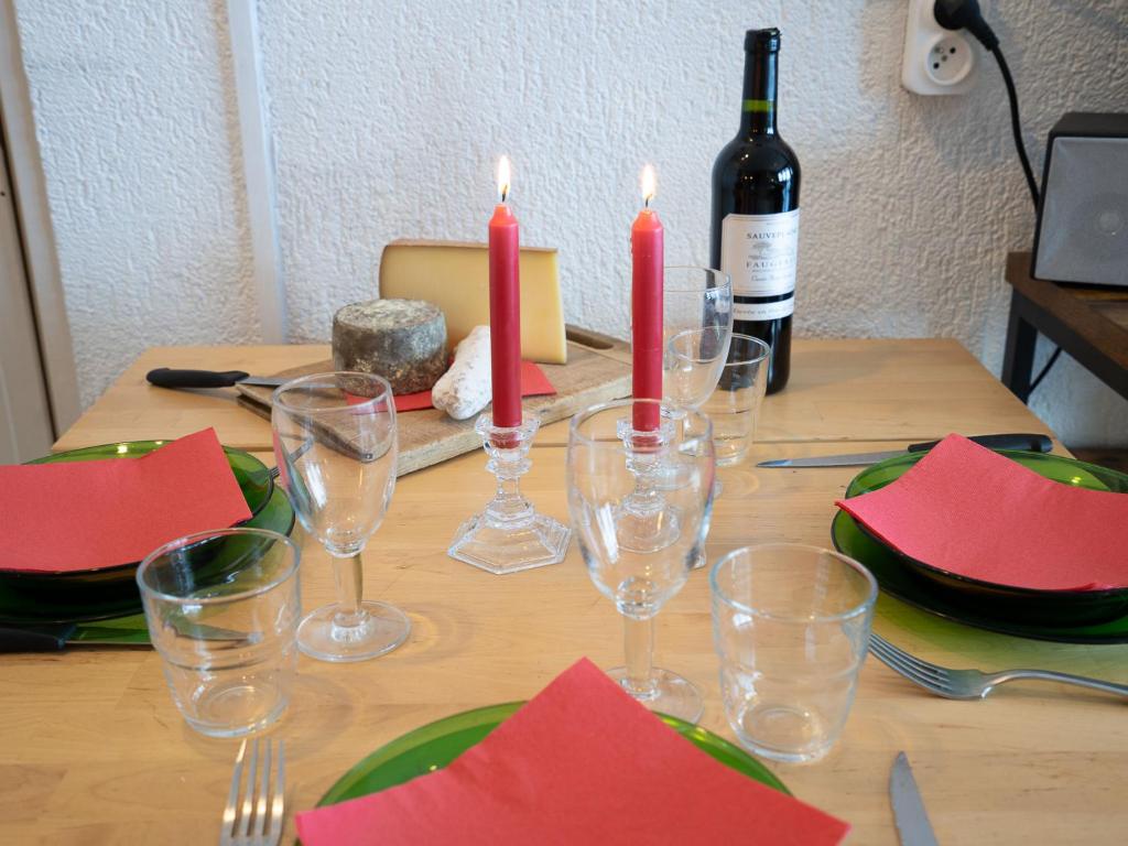 - une table avec des verres à vin, des serviettes rouges et des bougies dans l'établissement Apartment Le Curling B - Val Claret-30 by Interhome, à Tignes
