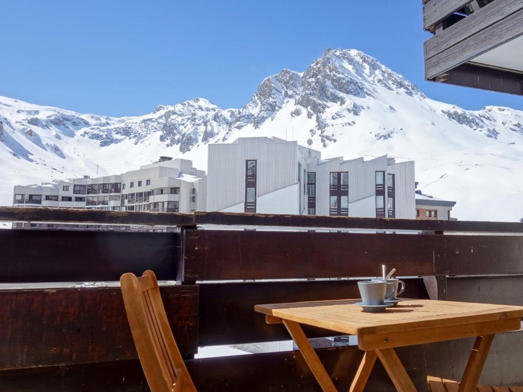 d'une table et d'une chaise sur un balcon avec une montagne enneigée. dans l'établissement Apartment Le Prariond - Val Claret-7 by Interhome, à Tignes