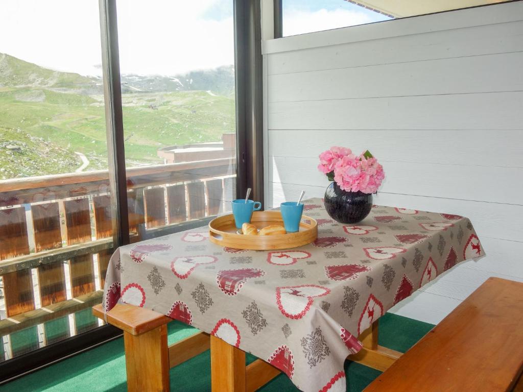 une table avec deux tasses et un vase de fleurs sur elle dans l'établissement Studio Sérac V7 by Interhome, à Val Thorens