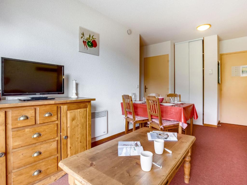 un salon avec une télévision et une table avec des chaises dans l'établissement Apartment Bâtiment B-19 by Interhome, au Corbier