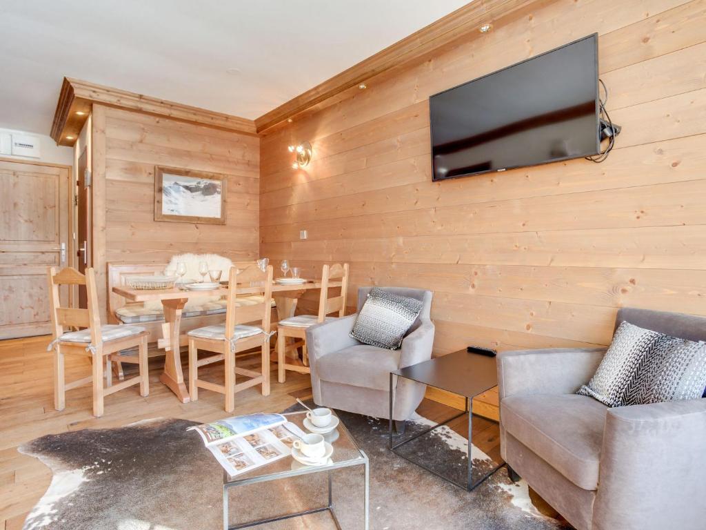 un salon avec une table et une télévision sur un mur dans l'établissement Apartment Le Prariond - Val Claret-10 by Interhome, à Tignes