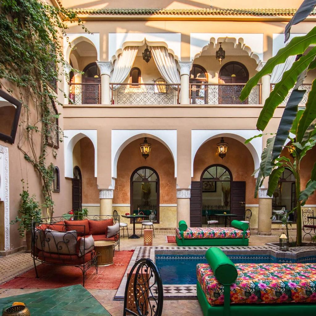 une cour avec des canapés et des tables dans un bâtiment dans l'établissement Riad Nabila, à Marrakech