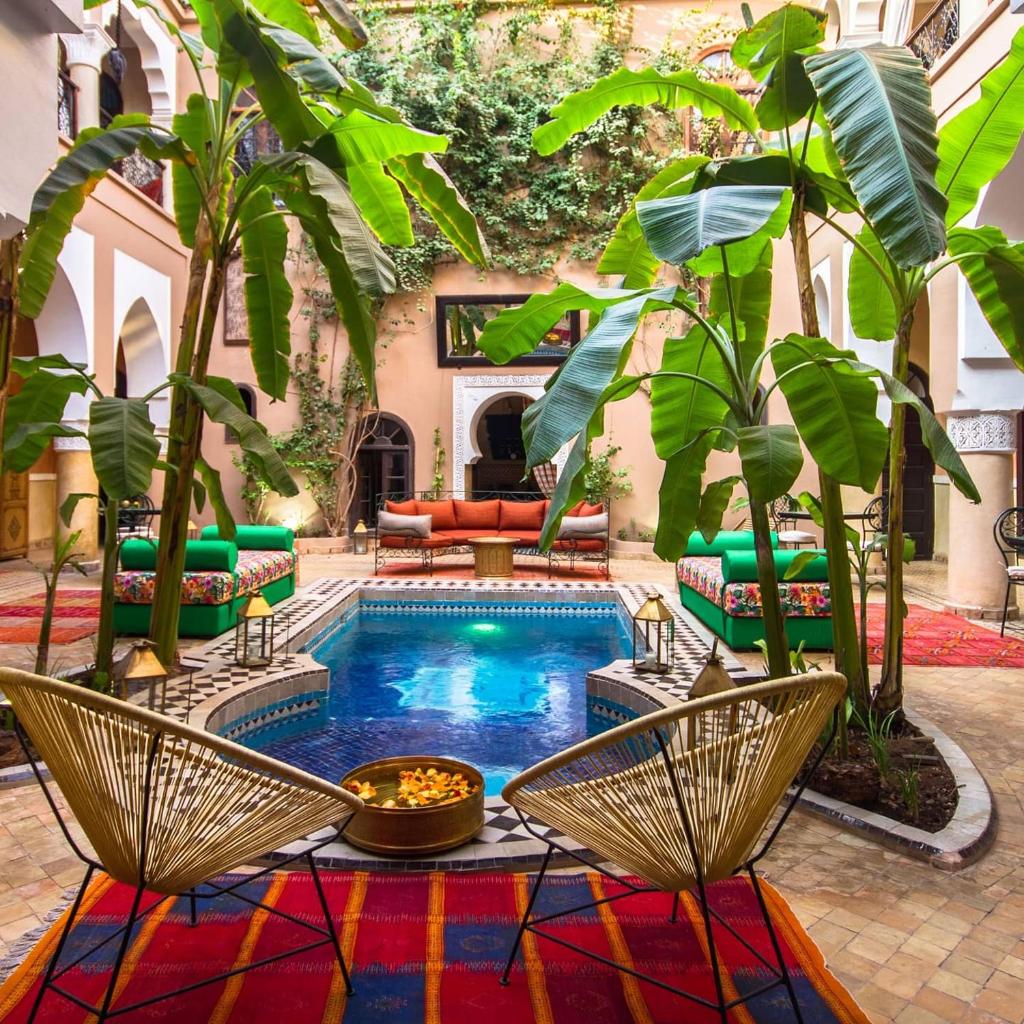 - une cour avec une piscine, des chaises et une table dans l'établissement Riad Nabila, à Marrakech