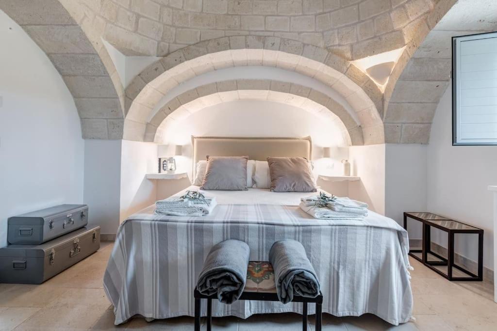 - une chambre avec un grand lit et un plafond en pierre dans l'établissement Trulli Gianpaolo - Luxury Villa, à Ostuni