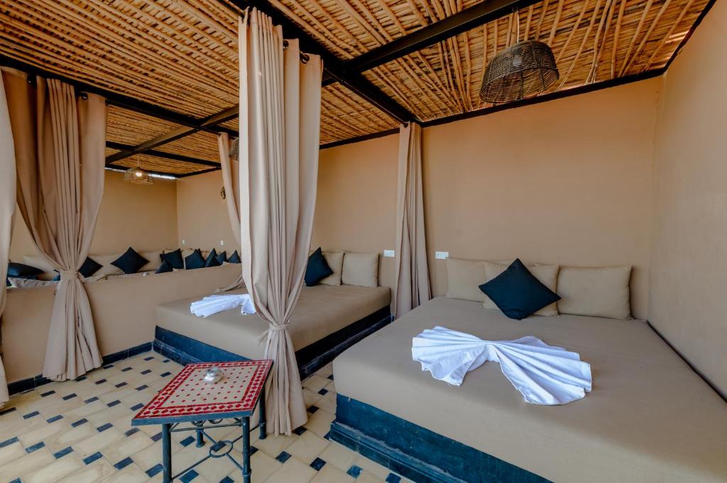 - 2 lits dans une chambre avec des rideaux et une table dans l'établissement Riad Amina, à Marrakech 36 autres photos