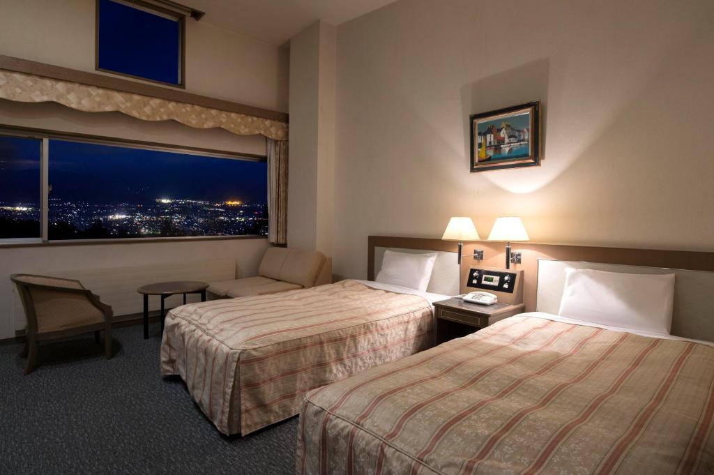 une chambre d'hôtel avec deux lits et une fenêtre dans l'établissement Izumigo AMBIENT Azumino Hotel, à Azumino 47 autres photos