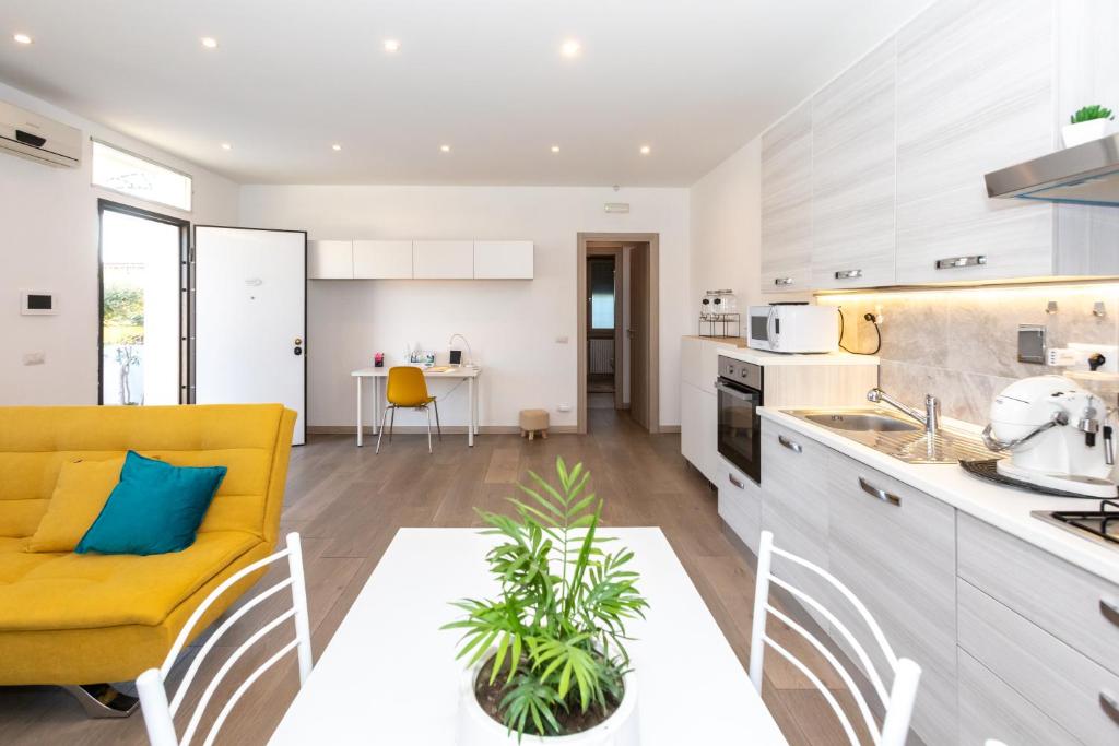 Il comprend une cuisine et un salon avec un canapé jaune. dans l'établissement La Piccola Villetta con il grande Giardino, à Rome