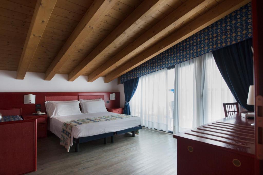 une chambre avec un grand lit et de grandes fenêtres dans l'établissement Hotel Brioni Mare, à Lido di Jesolo