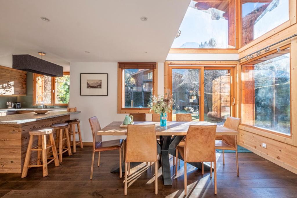 - une cuisine avec une table en bois, des chaises et des fenêtres dans l'établissement Nice And Spacious Apt In Chamonix Mont Blanc, à Chamonix-Mont-Blanc 18 autres photos