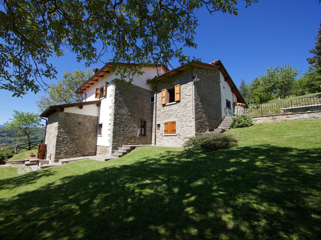 une maison sur une colline avec une pelouse verte dans l'établissement La Scatolaia, à Stia