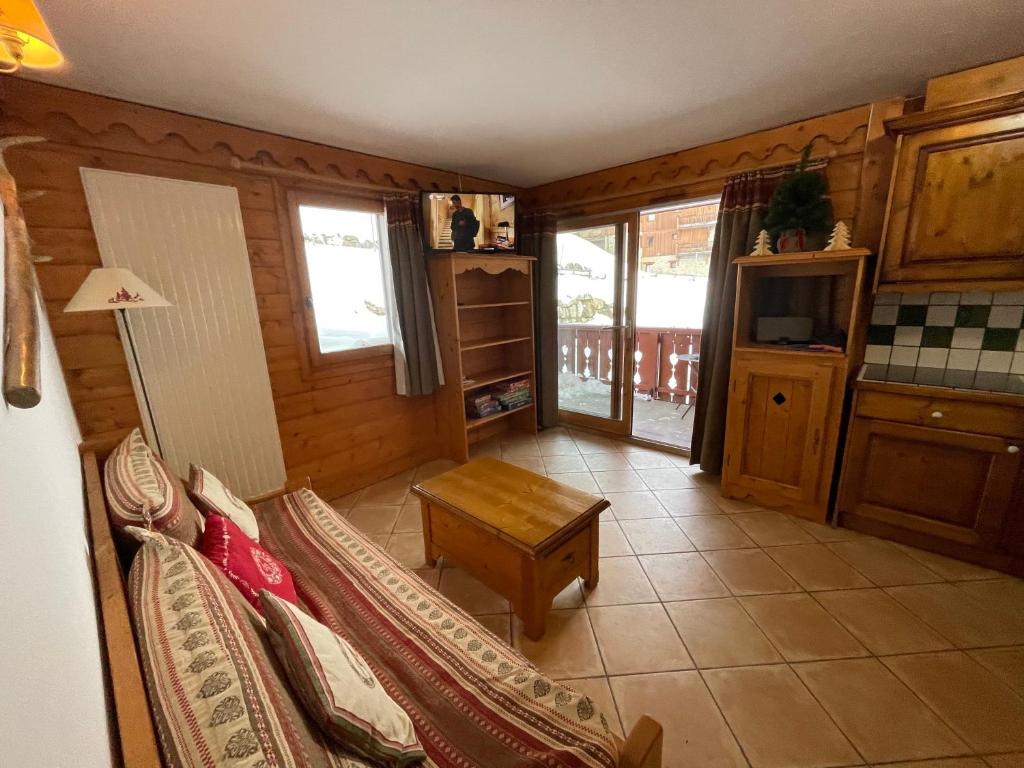 un salon avec un canapé et une table dans l'établissement Appartement ski aux pieds dans résidence premium piscine, sauna hamam, aux Menuires