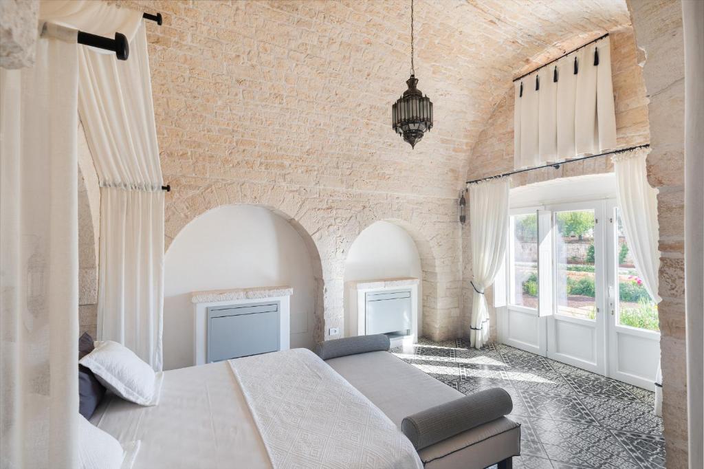 une chambre avec un grand lit et un mur de briques dans l'établissement Trullo Ermes, à Alberobello 39 autres photos