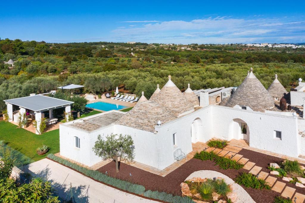une vue aérienne d'une maison blanche avec piscine dans l'établissement Trullo Ermes, à Alberobello