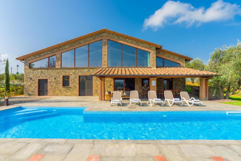 une villa avec piscine devant une maison dans l'établissement Villa Il Girasole, à Parrano