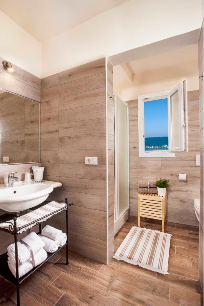 une salle de bain avec un lavabo et un miroir dans l'établissement Hotel Sayonara, à Cattolica
