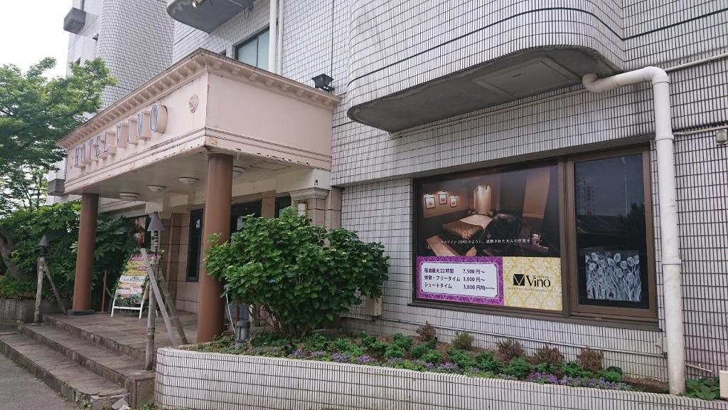 une devanture de magasin avec une enseigne dans la vitrine dans l'établissement Hotel VINO Adult Only, à Kawaguchi
