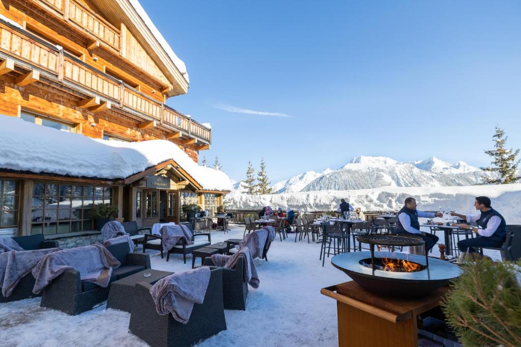 un restaurant avec des montagnes enneigées en arrière-plan dans l'établissement Grand Hôtel Courchevel 1850, à Courchevel