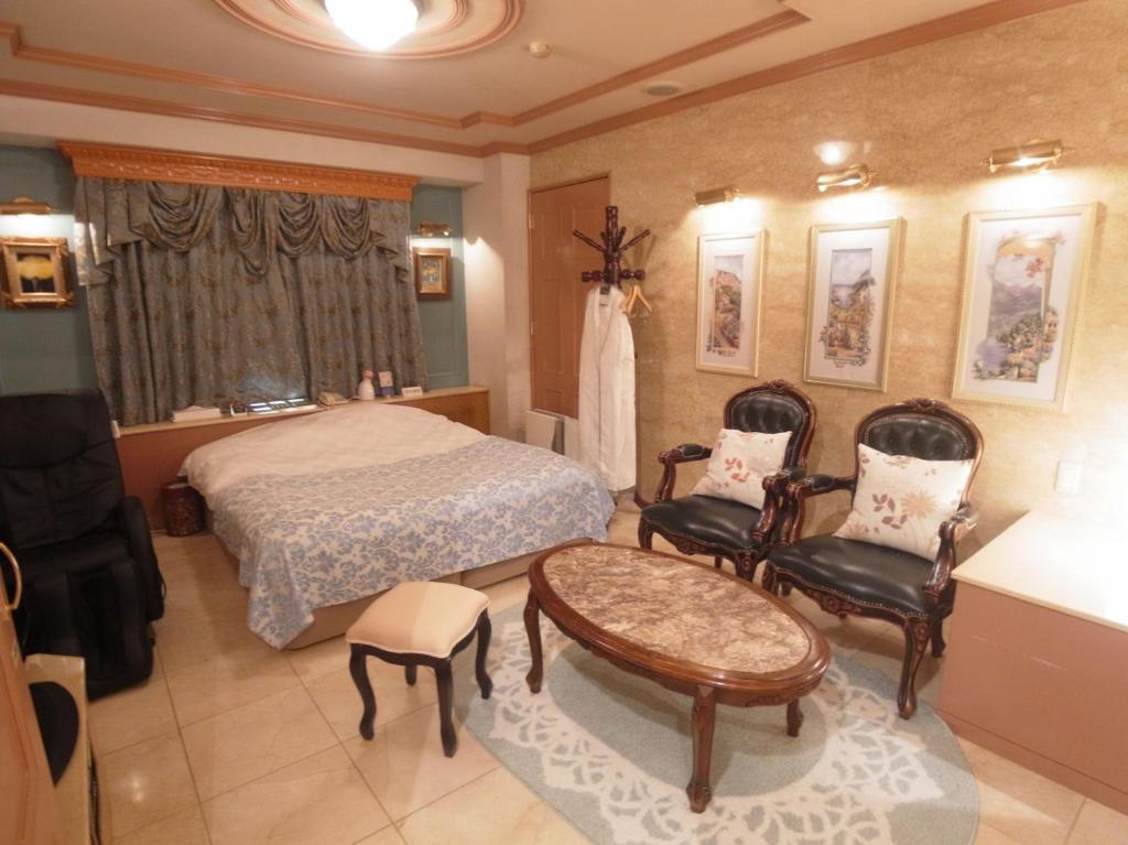 une chambre avec un lit, une table et des chaises dans l'établissement Hotel VINO Adult Only, à Kawaguchi
