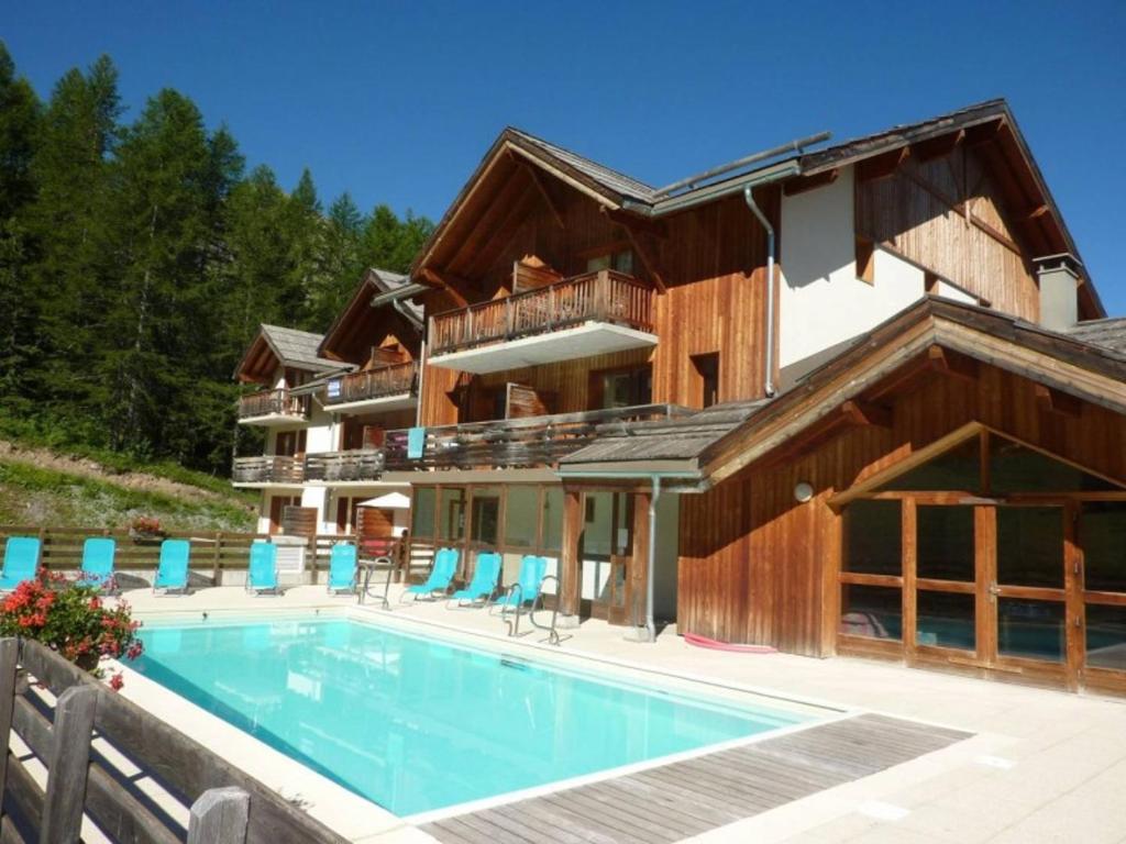 une maison avec une piscine devant dans l'établissement Le Soleil des Orres - maison pied des pistes - piscine, sauna et hammam, aux Orres