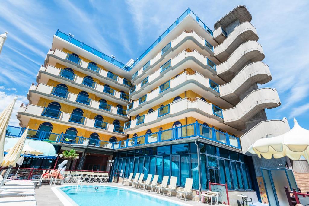 un hôtel avec une piscine devant dans l'établissement Hotel Brioni Mare, à Lido di Jesolo