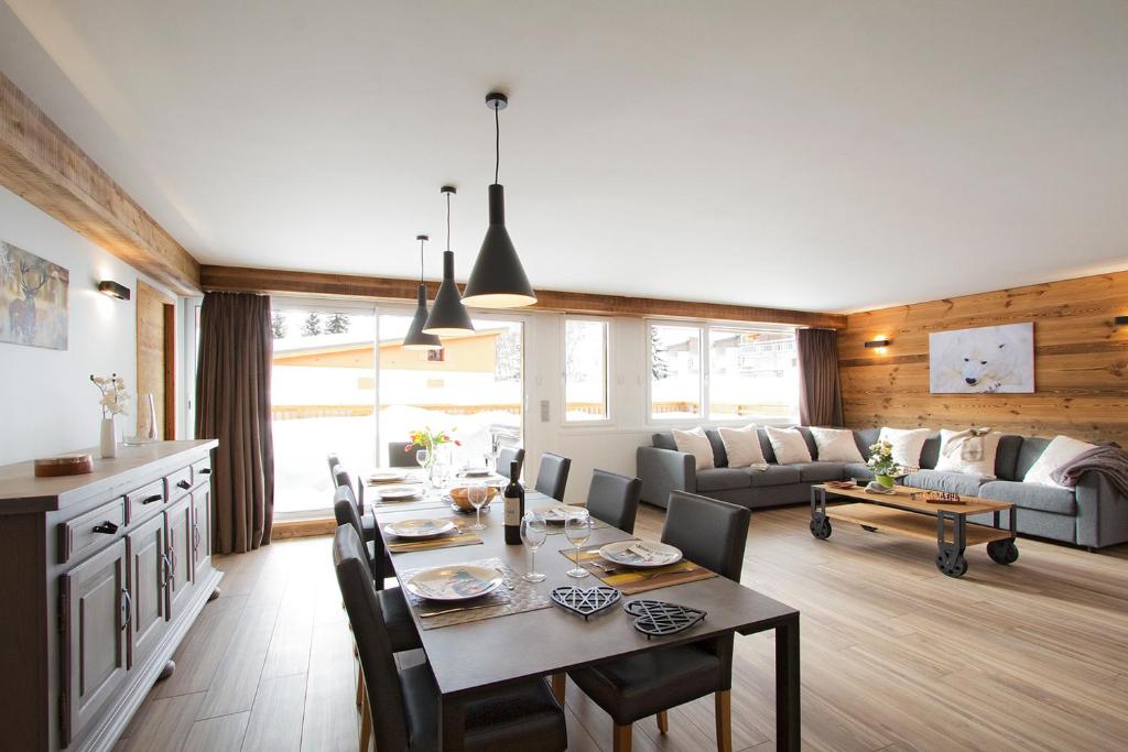 une salle à manger et un salon avec une table et des chaises dans l'établissement Le Gilélia, à Les Deux Alpes