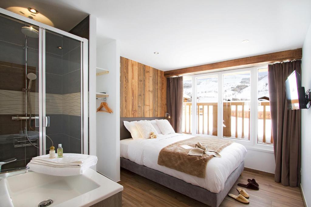 une chambre avec un grand lit et une baignoire dans l'établissement Le Gilélia, à Les Deux Alpes