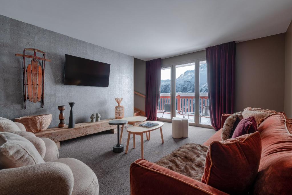 un salon avec un canapé et une table dans l'établissement ILY Hotels & Spa La Rosiere, à La Rosière