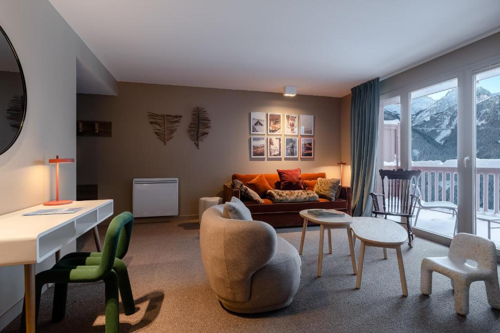 un salon avec un canapé, une table et des chaises dans l'établissement ILY Hotels & Spa La Rosiere, à La Rosière
