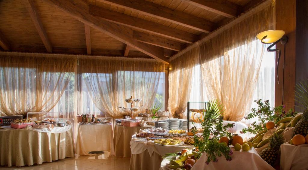 une salle à manger avec des tables et de la nourriture dans l'établissement Garden Hotel Ripa, à Vieste