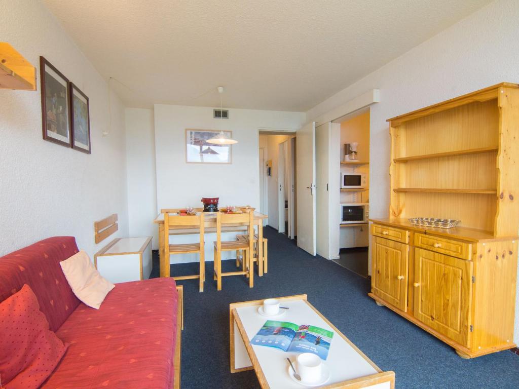 un salon avec un canapé rouge et une table dans l'établissement Apartment Lunik Orion-29 by Interhome, au Corbier
