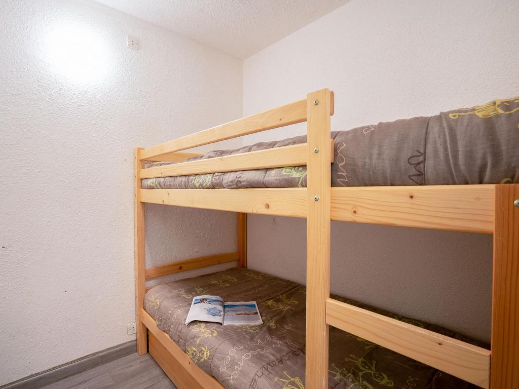 Ce lit superposé en bois se trouve dans une petite chambre. dans l'établissement Studio Lunik Orion-28 by Interhome, au Corbier