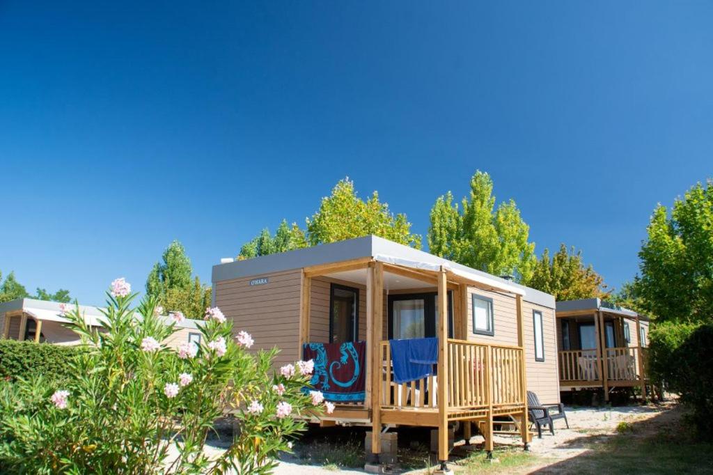 une petite maison dans une cour avec des arbres dans l'établissement Camping Parc Mogador, à Sanary-sur-Mer