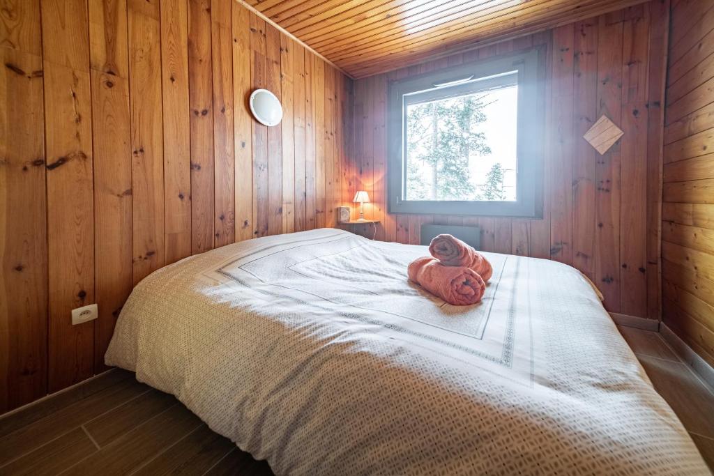 une chambre avec un lit avec une serviette dessus dans l'établissement Chalet des Ecureuils - 3 étoiles au pied des pistes, aux Angles