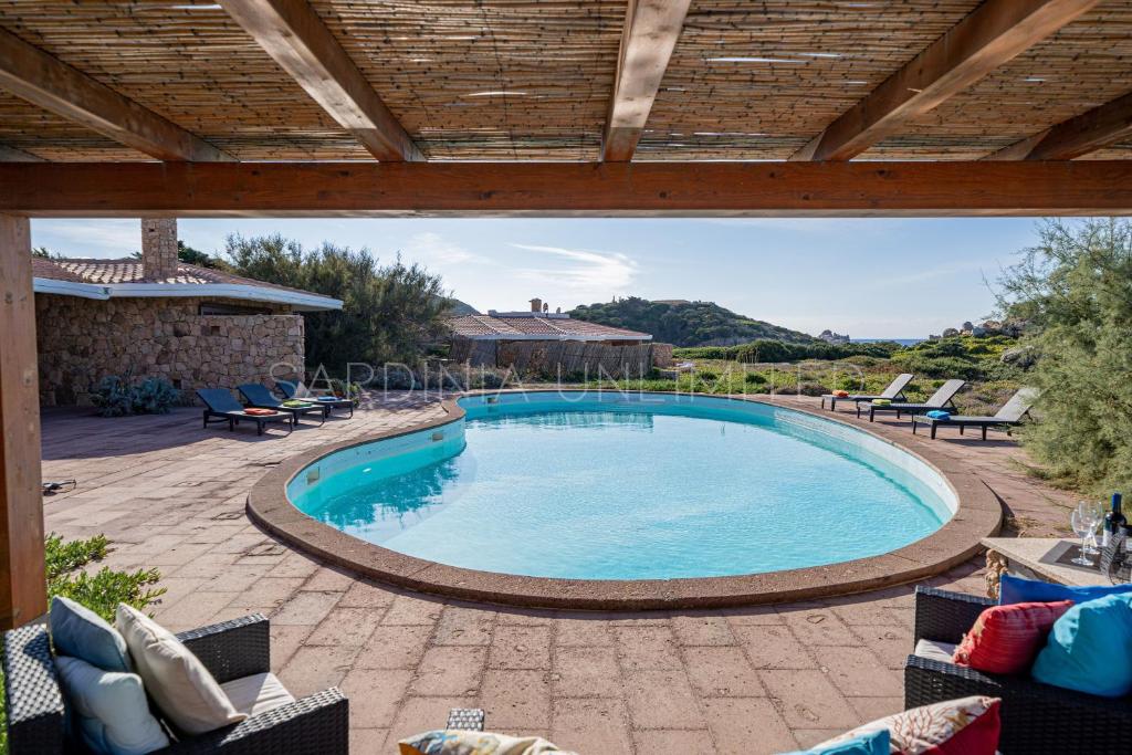 une piscine dans un patio avec des chaises dans l'établissement Mariu e Amelie, à Greuli