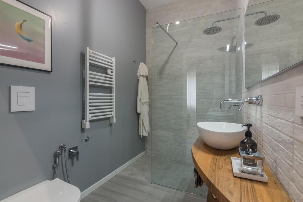 une salle de bain avec un lavabo et une douche en verre dans l'établissement Al Quadrato, à Piobbico