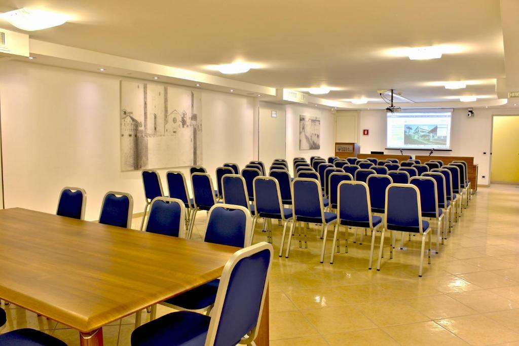 une salle de conférence avec une table en bois et des chaises bleues dans l'établissement Hotel Villa Tirreno, à Tarquinia 56 autres photos