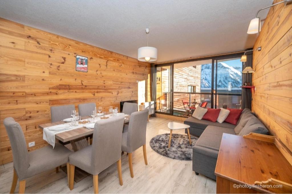 - une salle à manger et un salon avec un mur en bois dans l'établissement Appartement Queyrelet Orcières, à Orcières