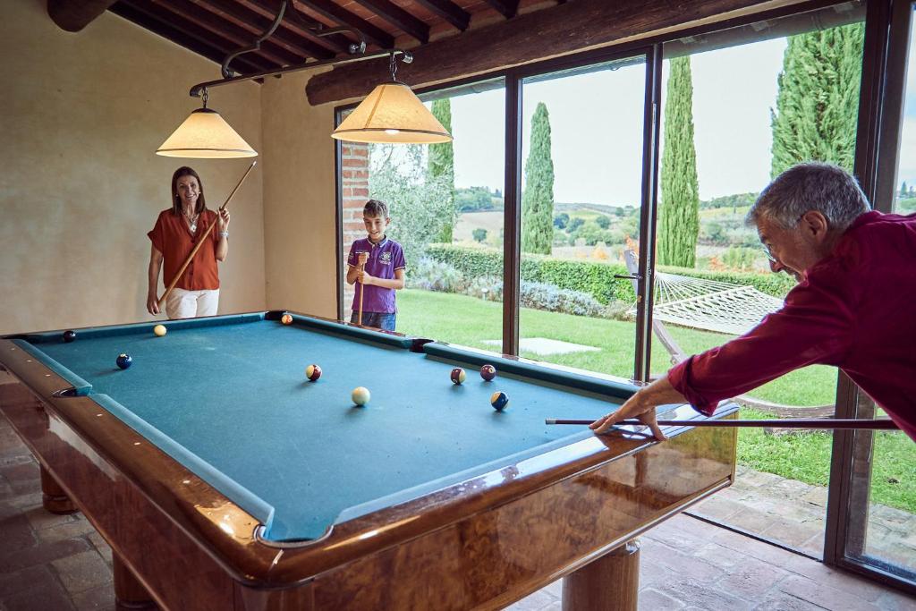 un homme et une femme jouant au billard dans l'établissement Tenuta Golo Luxury Villa - Wine Estate with Pool near Montepulciano, à Montepulciano