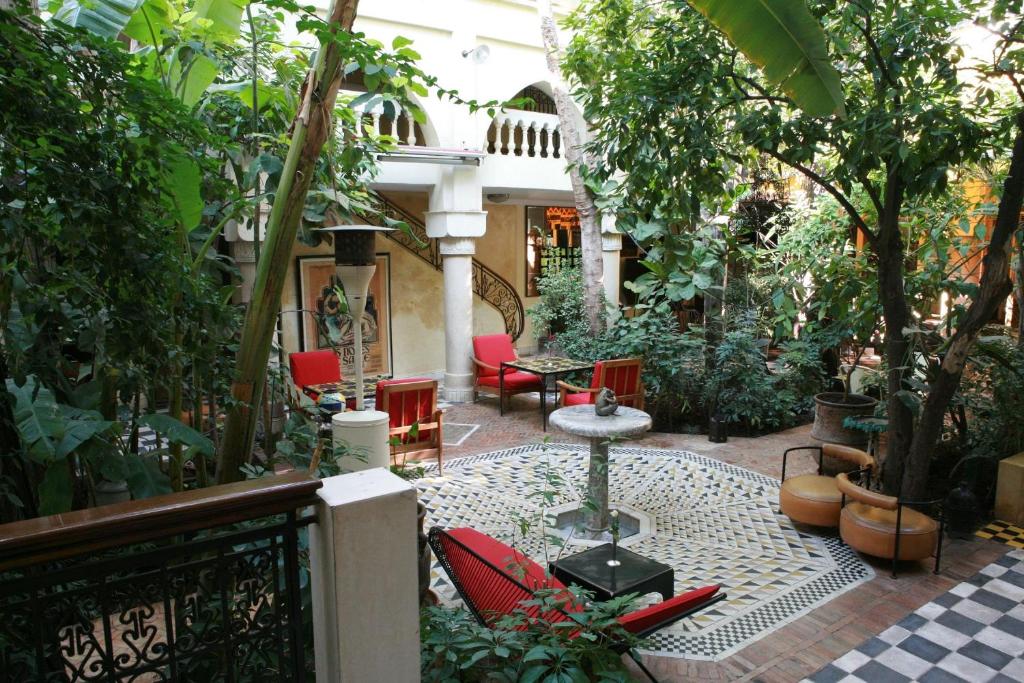 d'une terrasse avec des chaises et une table dans le jardin. dans l'établissement Riad Malika, à Marrakech