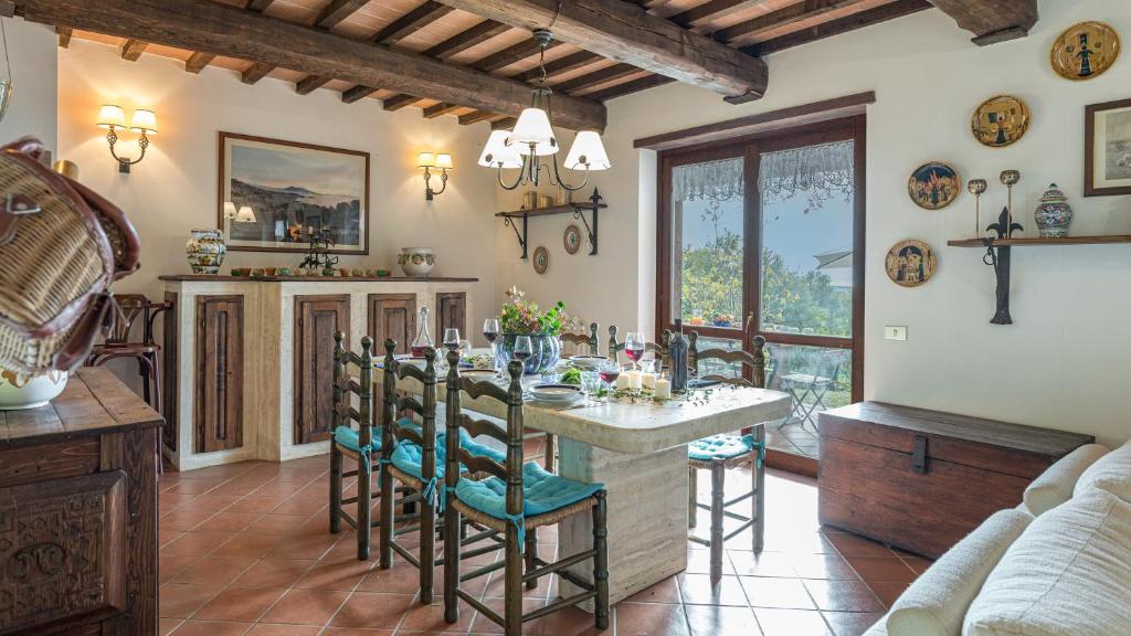 une cuisine avec une table et des chaises dans une pièce dans l'établissement Villa Paola 6, Emma Villas, à Gualdo Cattaneo
