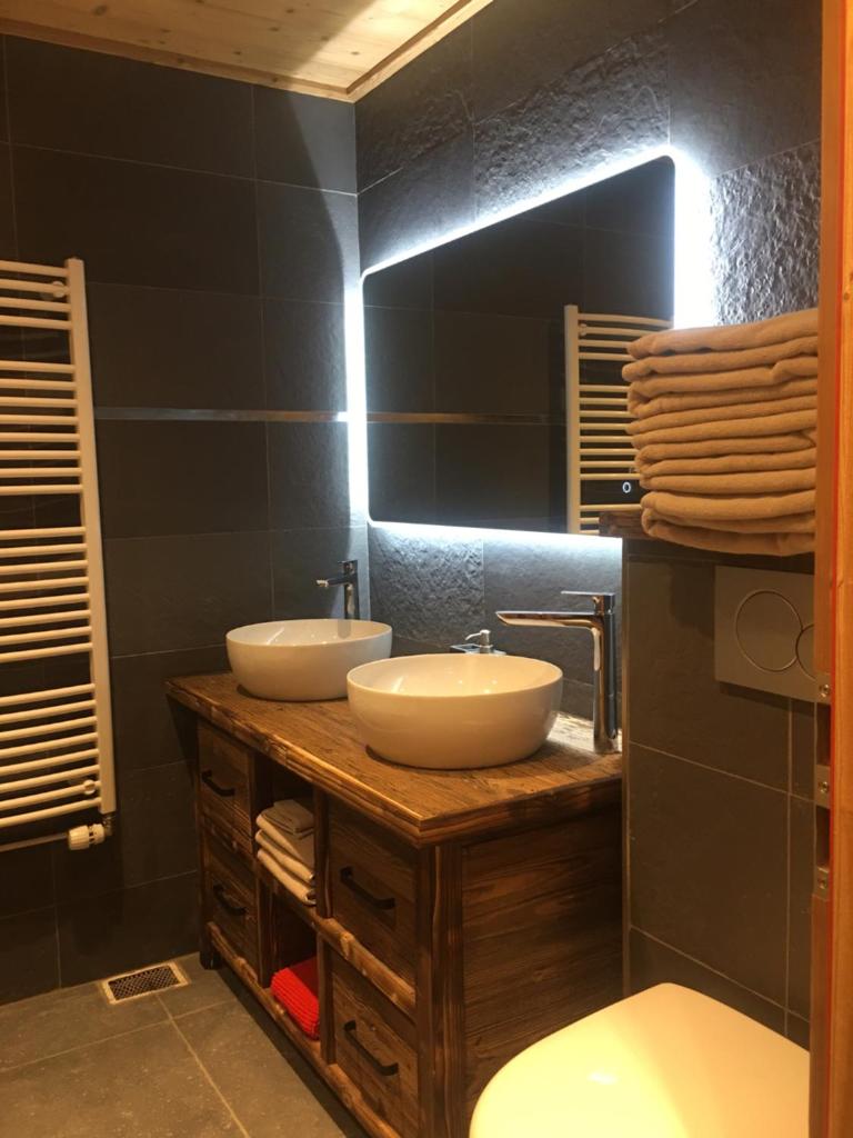 une salle de bain avec deux lavabos et un WC dans l'établissement Apartment Anna, à Courchevel