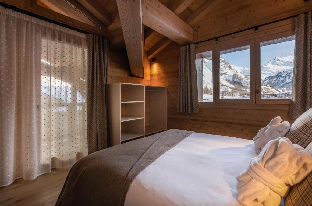 - une chambre avec un lit et une vue sur la montagne dans l'établissement Chalet Hôtelier LES EQUINOXES - VAL D'ISERE, à La Daille 37 autres photos